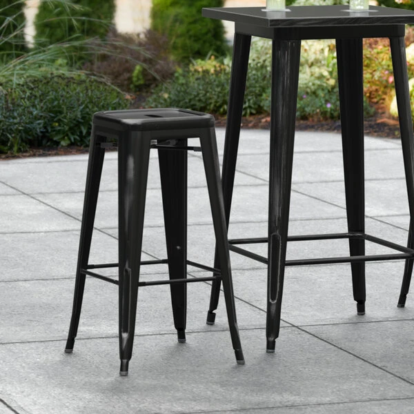 Brand new ๐ LT&S Alloy Series Lancaster Table & Seating Alloy Series Distressed Black Stackable Metal Indoor / Outdoor Industrial Barstool With Drain Hole Seat โ